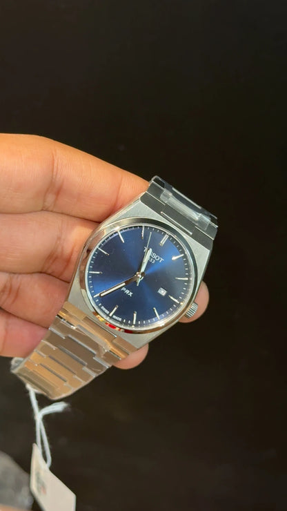 Tissot PRX silver chain with blue dial.