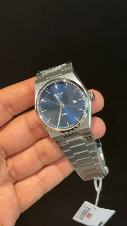 Tissot PRX silver chain with blue dial.