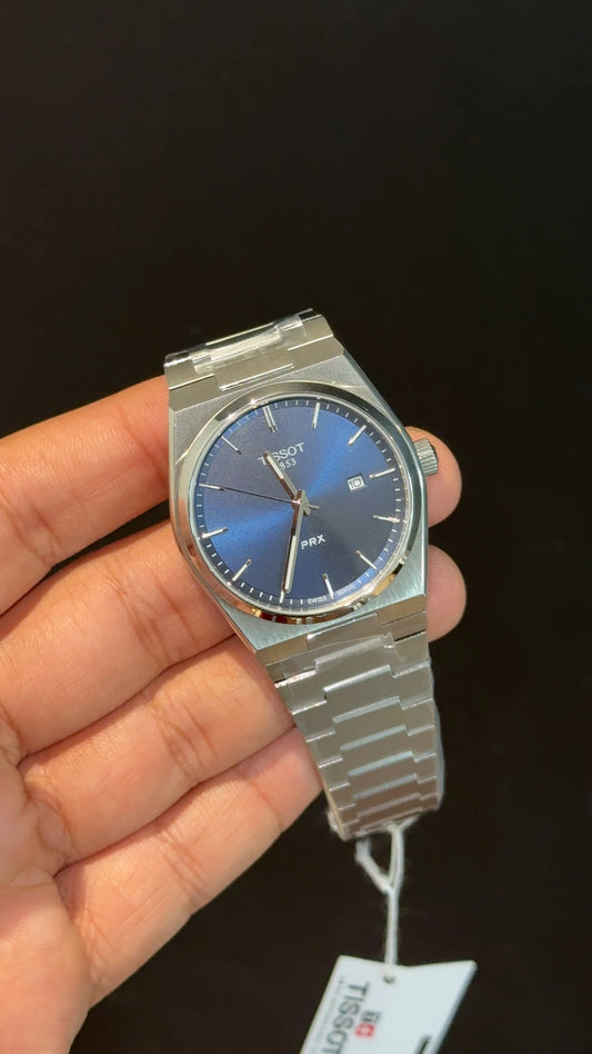 Tissot PRX silver chain with blue dial.