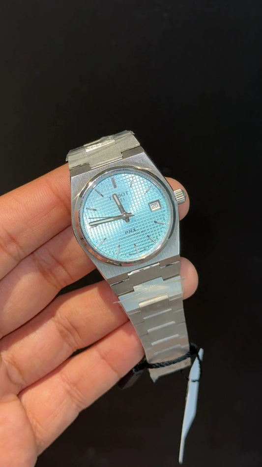 Tissot PRX silver chain with blue texture dial.